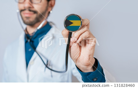 Doctor holding stethoscope with Bahamas flag. Bahamas health and care concept. Bahamas flag on stethoscope 131828460