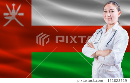 Female doctor on Oman flag. Doctor with crossed arms on Oman flag. Oman health and care concept 131828519