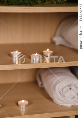 Relaxing atmosphere created by soft candlelight and neatly stacked towels in a spa setting, inviting tranquility and peace during a wellness retreat 131828771