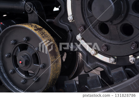 Close view of industrial machinery gears working together to showcase engineering details in a factory setting during daylight hours Close view of industrial machinery gears working together to showcase engineering details in a factory setting during daylight hours 131828786