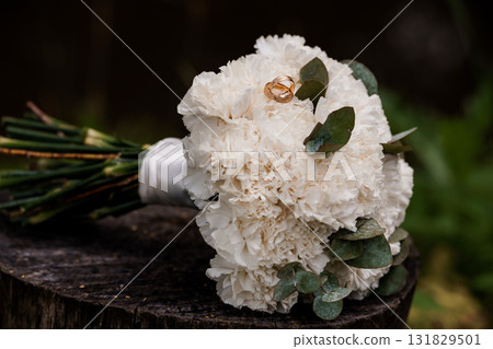 Rustic Wedding Rings and White Carnation Bouquet on Wood Romantic Love, Engagement, Celebration, Natural Floral Arrangement, Cream and Green Tones 131829501