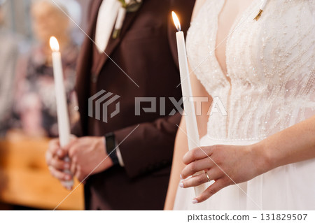 Wedding Unity Candle Ceremony: Bride and Groom Lighting Candles in Church, White Gowns and Formal Attire, Soft Light, Symbolic Celebration Wedding Unity Candle Ceremony: Bride and Groom Lighting Candles in Church, White Gowns and Formal Attire, Soft Light, Symbolic Celebration 131829507