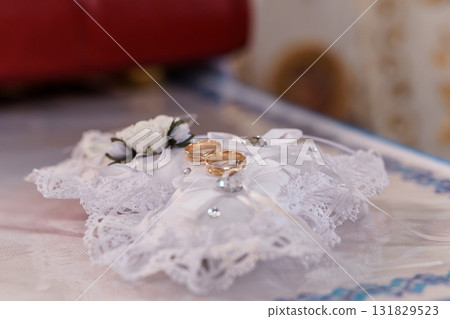 Elegant Wedding Rings on White Pillow, Close-Up Shot, Floral Decoration, Gold Bands, Lace Fabric, Symbolic Love and Commitment, Soft Lighting Elegant Wedding Rings on White Pillow, Close-Up Shot, Floral Decoration, Gold Bands, Lace Fabric, Symbolic Love and Commitment, Soft Lighting 131829523