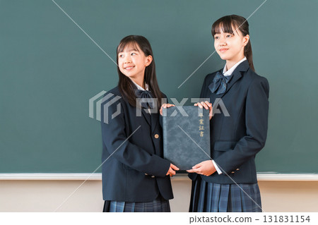 High school student/girl holding a diploma in front of a blackboard in the classroom (graduate/graduation ceremony/graduation) High school student/girl holding a diploma in front of a blackboard in the classroom (graduate/graduation ceremony/graduation) 131831154
