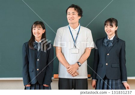 教室黑板前,一位男老師和一群小學、國中和高中的女生 教室黑板前,一位男老師和一群小學、國中和高中的女生 131831237