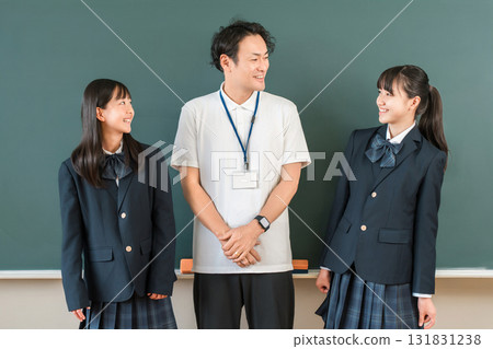 教室黑板前,一位男老師和一群小學、國中和高中的女生 教室黑板前,一位男老師和一群小學、國中和高中的女生 131831238