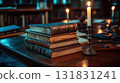 A stack of books is on a table with a candle in front of it 131831241
