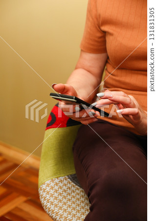 vertical image of a woman using her mobile smart phone. woman scrolling vertical mobile smart phone touch using indoor 131831305