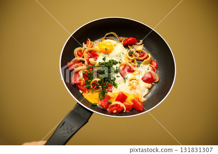 shakshuka frying pan modern tomato onion greens background olive. scrambled eggs frying pan modern food olive oil. A colorful, modern food 131831307