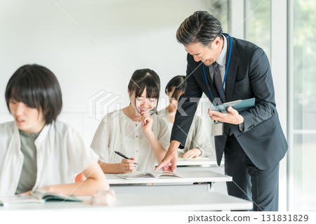 在補習班、課外活動、學校課程和暑期課程學習的小學生和男教師 在補習班、課外活動、學校課程和暑期課程學習的小學生和男教師 131831829