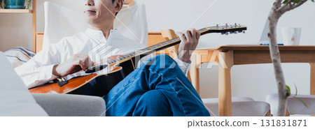 Middle-aged man playing guitar in the living room 131831871