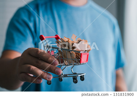 Hand holding shopping cart with coupons home indoor close-up consumer savings Hand holding shopping cart with coupons home indoor close-up consumer savings 131831900