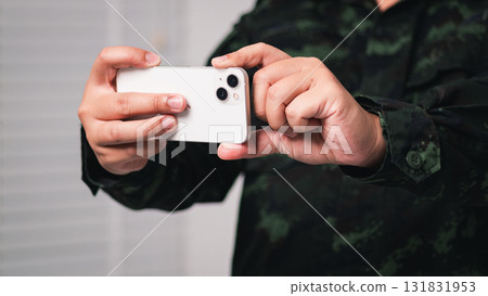 Capturing moments soldier using smartphone urban setting close-up perspective modern life 131831953