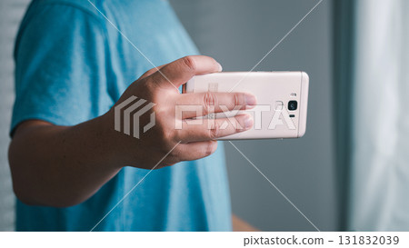 Capturing moments hand holding smartphone indoor setting personal space close-up view digital connection Capturing moments hand holding smartphone indoor setting personal space close-up view digital connection 131832039