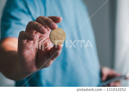 Hand holding a coin focus business setting close-up shot indoor environment financial concept Hand holding a coin focus business setting close-up shot indoor environment financial concept 131832052