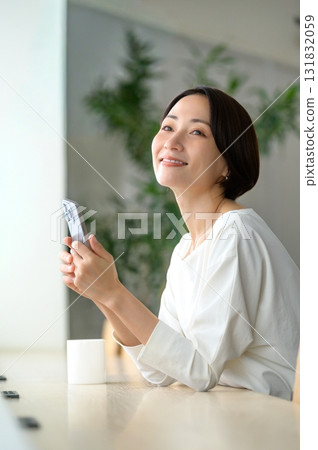 A woman using her smartphone in a cafe A woman using her smartphone in a cafe 131832059