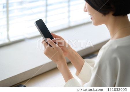A woman using her smartphone in a cafe A woman using her smartphone in a cafe 131832095