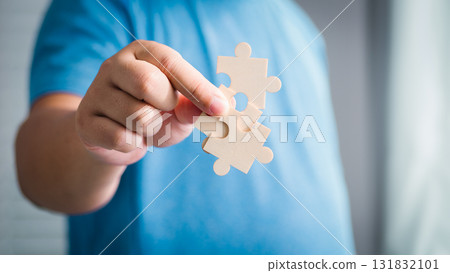 Child assembles puzzle pieces home setting indoor activity creative play focused exploration Child assembles puzzle pieces home setting indoor activity creative play focused exploration 131832101