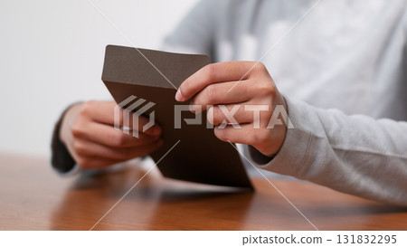 Unboxing a mysterious package indoor setting close-up shot cozy atmosphere engaging concept 131832295