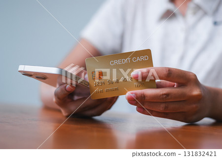 Online shopping action with credit card hand home office setting financial transaction personal perspective Online shopping action with credit card hand home office setting financial transaction personal perspective 131832421