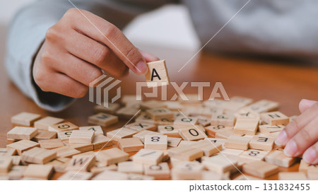 Engaging word building game at home table enhance language skills and creativity indoors with close-up focus Engaging word building game at home table enhance language skills and creativity indoors with close-up focus 131832455