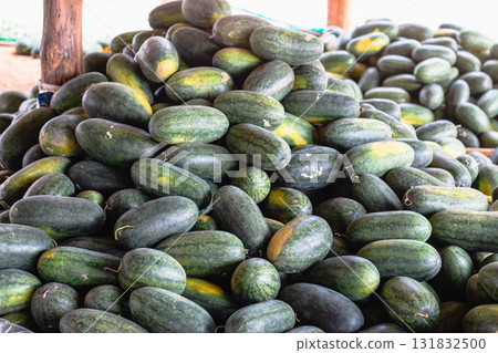 Fresh cucumbers piled high at local market vibrant display food rustic setting close-up view 131832500