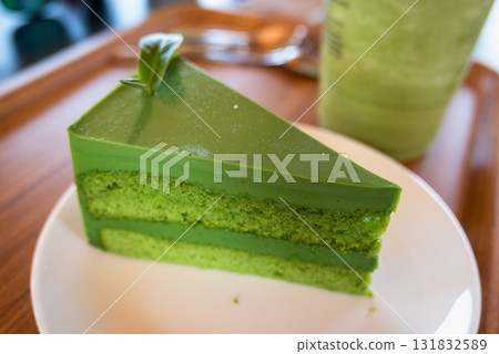 Indulge in a vibrant green matcha cake slice cozy setting culinary delight close-up experience Indulge in a vibrant green matcha cake slice cozy setting culinary delight close-up experience 131832589