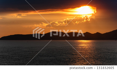 Dramatic sunset over mountainous coastline serene ocean landscape evening glow Dramatic sunset over mountainous coastline serene ocean landscape evening glow 131832605