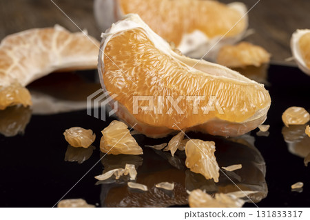 citrus on a black surface, ripe and sweet and juicy citrus is reflected on the black surface, close up citrus on a black surface, ripe and sweet and juicy citrus is reflected on the black surface, close up 131833317