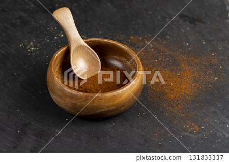 wooden spoon filled with spices from dried and ground sweet pepper, aromatic spices from dried red pepper wooden spoon filled with spices from dried and ground sweet pepper, aromatic spices from dried red pepper 131833337