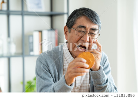 Senior man eating rice crackers Senior man eating rice crackers 131833896