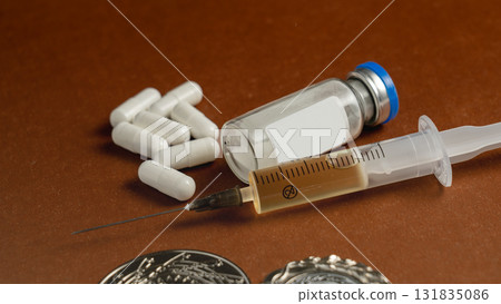 Syringes, medals, and pills on a blue background represent doping in sports, the abuse of anabolic steroids by athletes, and sports fraud. 131835086