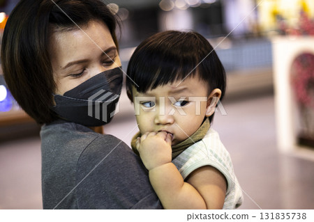 Mother gently holding baby in arms, touching scene for advertising, maternity campaigns, emotional photography, and creative family-focused media content. 131835738