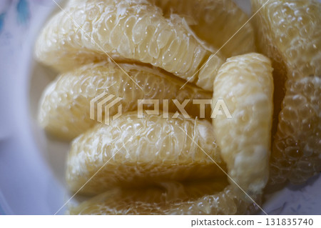 Peeled pomelo fruit displayed close up on a plate, ideal for food ads, restaurant visuals, wellness campaigns, and photography projects highlighting tropical freshness. 131835740
