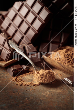 Broken bitter chocolate bar and cocoa powder. 131835909