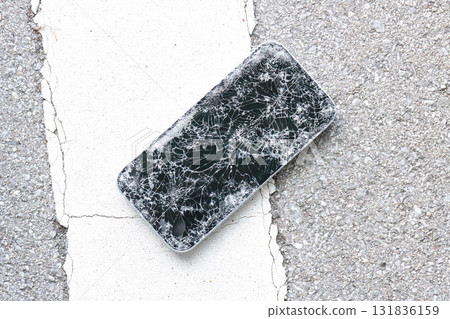 A broken smartphone dropped on the road 131836159