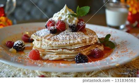 Delicious fluffy pancakes topped with fresh berries, whipped cream, and powdered sugar, served on a white plate 131836563