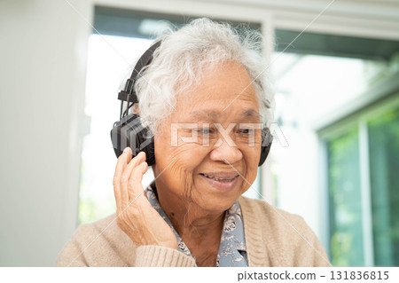 Asian senior woman patient happy to use earphone to listen relax music. 131836815
