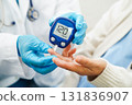 Asian doctor using digital glucose meter for check sample blood sugar level to treatment diabetes. 131836907