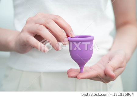 Asian woman holding menstrual cup for hygiene period cycle protection. Asian woman holding menstrual cup for hygiene period cycle protection. 131836964