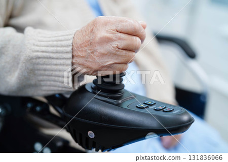 Asian elderly disability woman patient use joystick electric wheelchair in hospital. Asian elderly disability woman patient use joystick electric wheelchair in hospital. 131836966