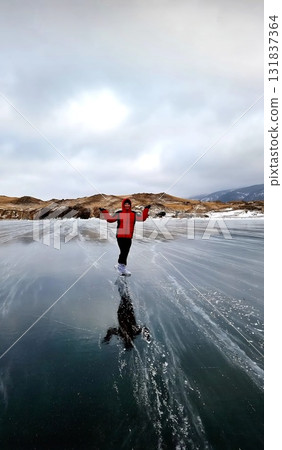 Figure skater posing triumphantly on vast, frozen Lake Baikal 131837364