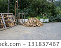A pile of firewood, consisting of various sizes and shapes of wood pieces, is stacked in an outdoor scene. 131837467