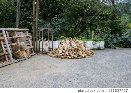 A pile of firewood, consisting of various sizes and shapes of wood pieces, is stacked in an outdoor scene. A pile of firewood, consisting of various sizes and shapes of wood pieces, is stacked in an outdoor scene. 131837467