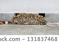A pile of firewood, consisting of various sizes and shapes of wood pieces, is stacked in an outdoor scene. 131837468