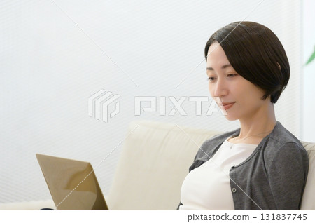 坐在沙發上用電腦工作的女人 131837745