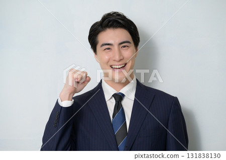 A man in a suit making a fist pump on a white background A man in a suit making a fist pump on a white background 131838130