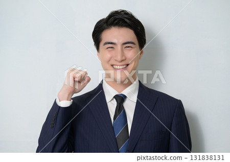 A man in a suit making a fist pump on a white background 131838131