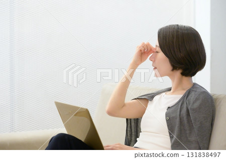 A woman holding her head due to work stress 131838497