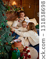 A happy family mother, father, and young son sitting close together in a cozy, festive living room 131838698